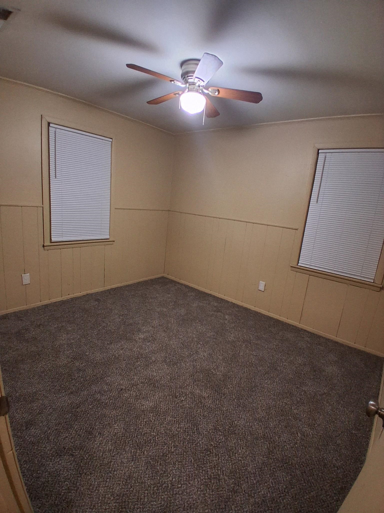 2435 Silver Street Memphis, TN 38106 - Photo 6 of 9 Spare room featuring carpet, wooden walls, and wainscoting
