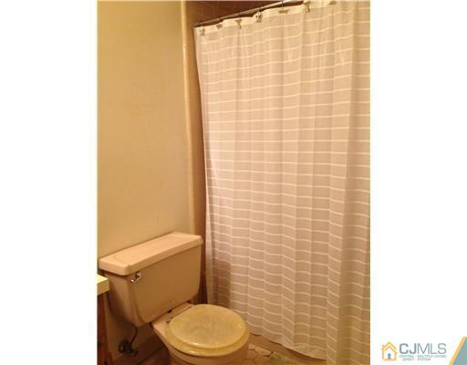 153 Redpine Loop Old Bridge, NJ 08857 - Photo 23 of 25 a white toilet sitting next to a shower curtain