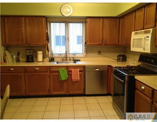 153 Redpine Loop Old Bridge, NJ 08857 - Photo 10 of 25 a kitchen with stainless steel appliances granite countertop a stove a sink and a microwave
