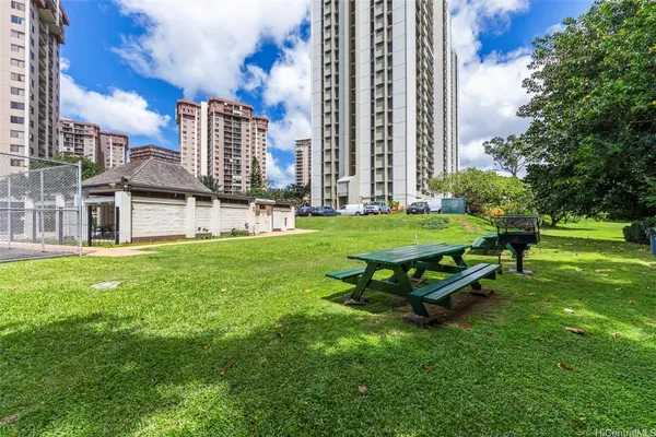 a garden with tall buildings in the background