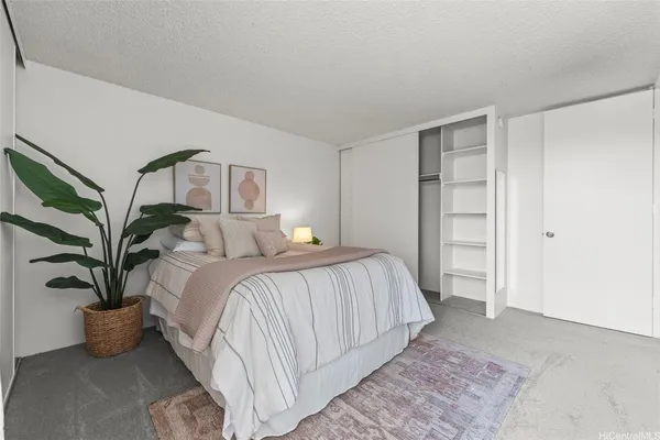 a bedroom with a large bed table and a potted plant