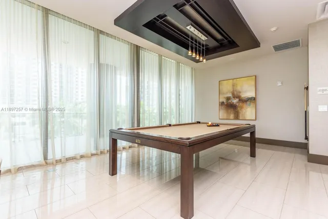 a room with pool table and windows