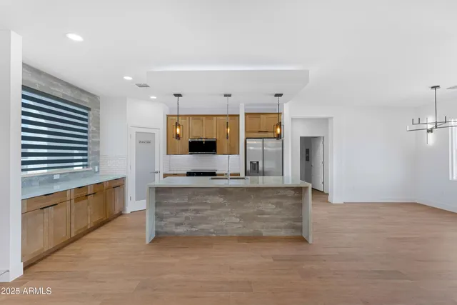 a kitchen with stainless steel appliances granite countertop a sink a stove and a refrigerator