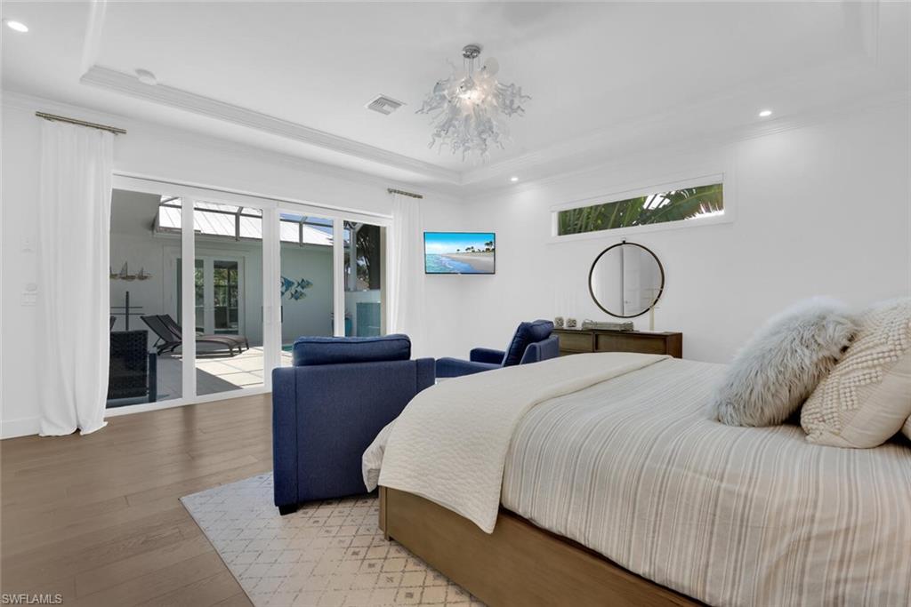 2130 Curtis Street Naples, FL 34112 - Photo 13 of 31 a bedroom with a large bed and wooden floor