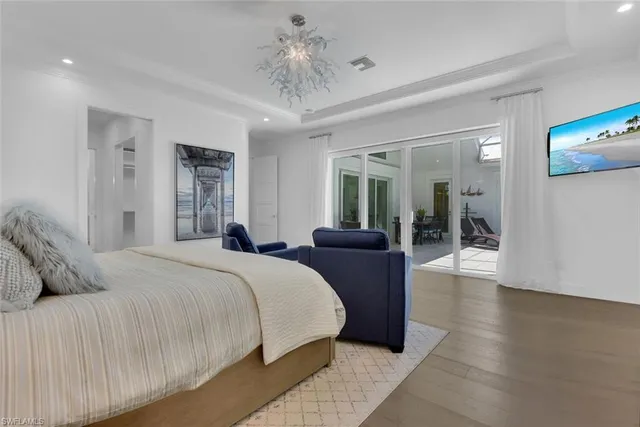 a bedroom with a large bed and wooden floor