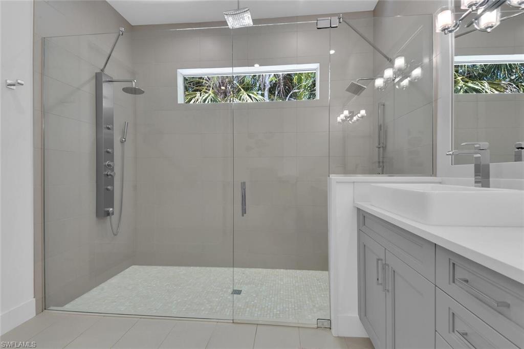 2130 Curtis Street Naples, FL 34112 - Photo 16 of 31 a bathroom with a sink a mirror and a shower