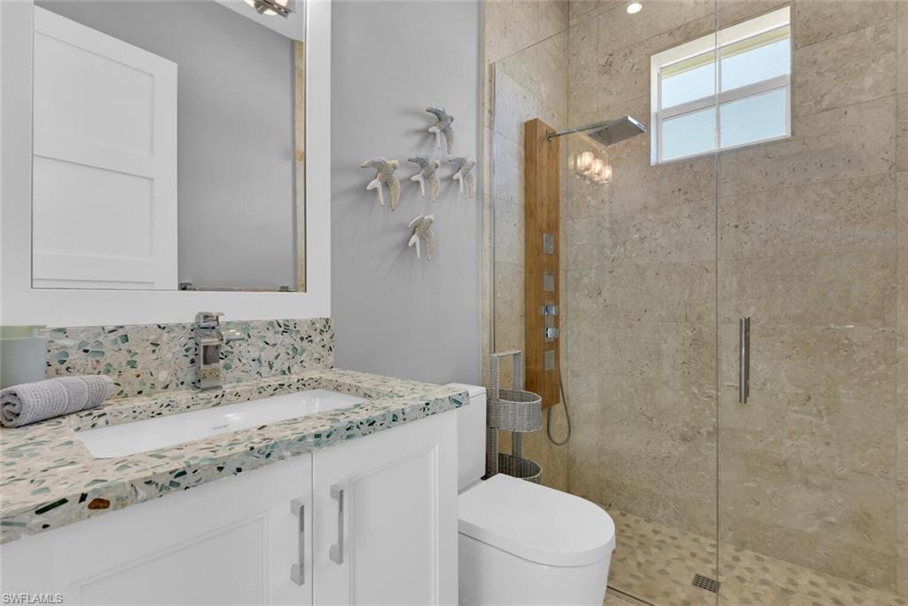 2130 Curtis Street Naples, FL 34112 - Photo 20 of 31 a bathroom with a granite countertop sink a toilet and shower