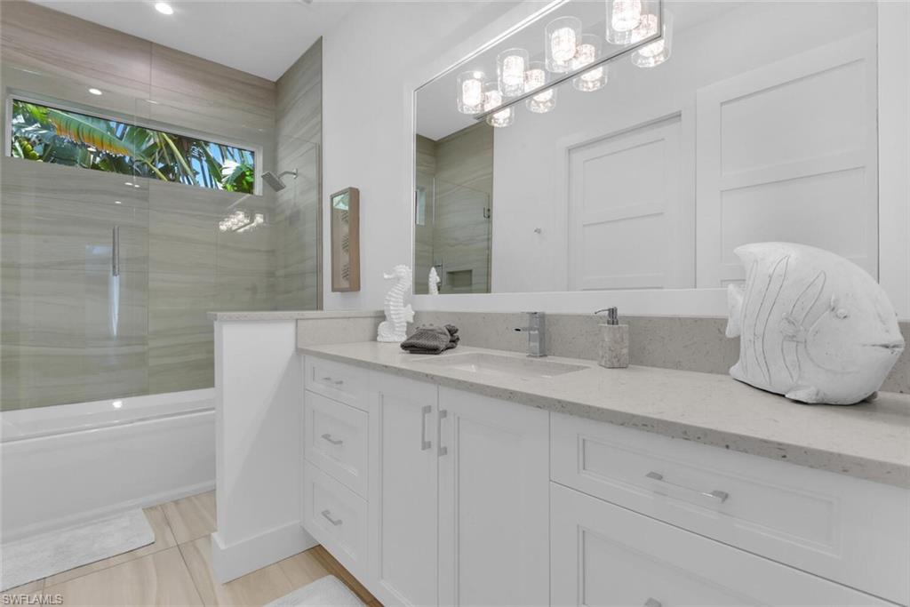 2130 Curtis Street Naples, FL 34112 - Photo 23 of 31 a bathroom with a sink a large mirror and a shower