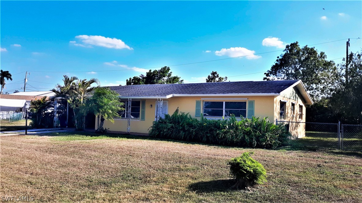 502 Wyoming Road Lehigh Acres, FL 33936 - Photo 1 of 20 a front view of a house with a yard and a garage
