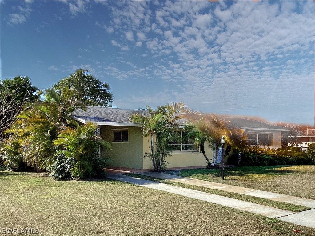 502 Wyoming Road Lehigh Acres, FL 33936 - Photo 2 of 20 a view of a house with a yard