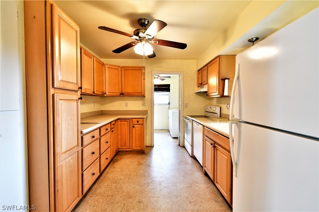 502 Wyoming Road Lehigh Acres, FL 33936 - Photo 7 of 20 a kitchen with stainless steel appliances a sink and a refrigerator