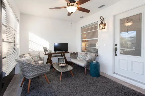 a living room with furniture a flat screen tv and a large window
