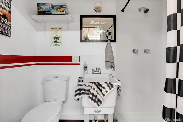 a bathroom with a toilet and a shower curtain