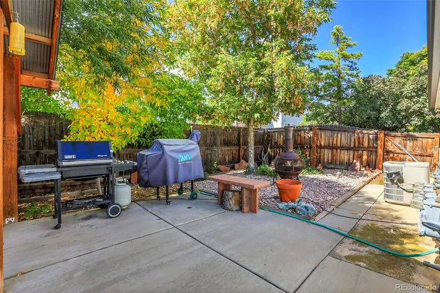 a backyard of a house with barbeque oven and outdoor seating