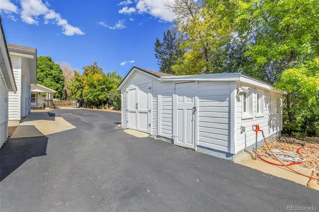 a view of a house with a small yard and large tree