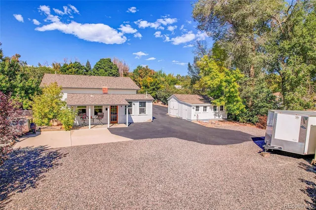 a view of a yard with table and chairs and wooden fence