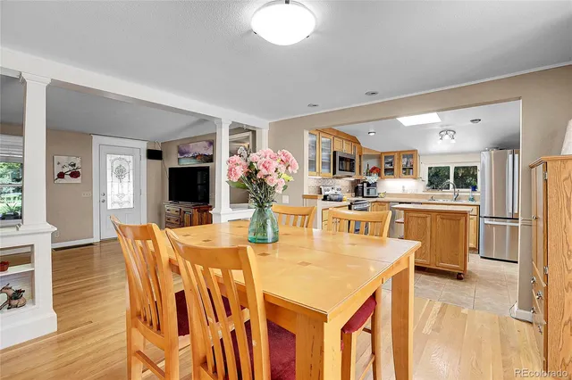 a dining hall with stainless steel appliances kitchen island granite countertop a dining table and chairs