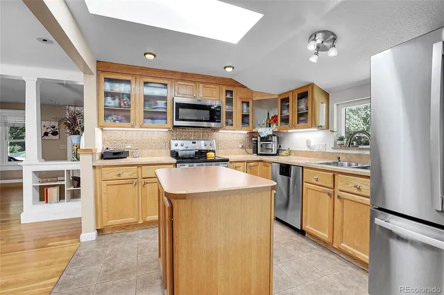 a kitchen with kitchen island a sink stove and refrigerator