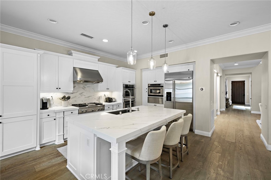 7 Julia Street Ladera Ranch, CA 92694 - Photo 17 of 52 a kitchen with stainless steel appliances a stove a sink a microwave a refrigerator white cabinets and chairs