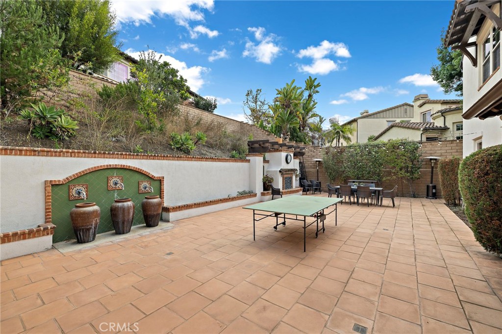 7 Julia Street Ladera Ranch, CA 92694 - Photo 25 of 52 a view of a patio with a table and chairs under an umbrella