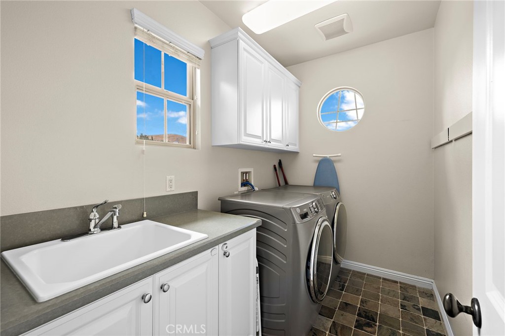 7 Julia Street Ladera Ranch, CA 92694 - Photo 34 of 52 a utility room with cabinets washer and dryer
