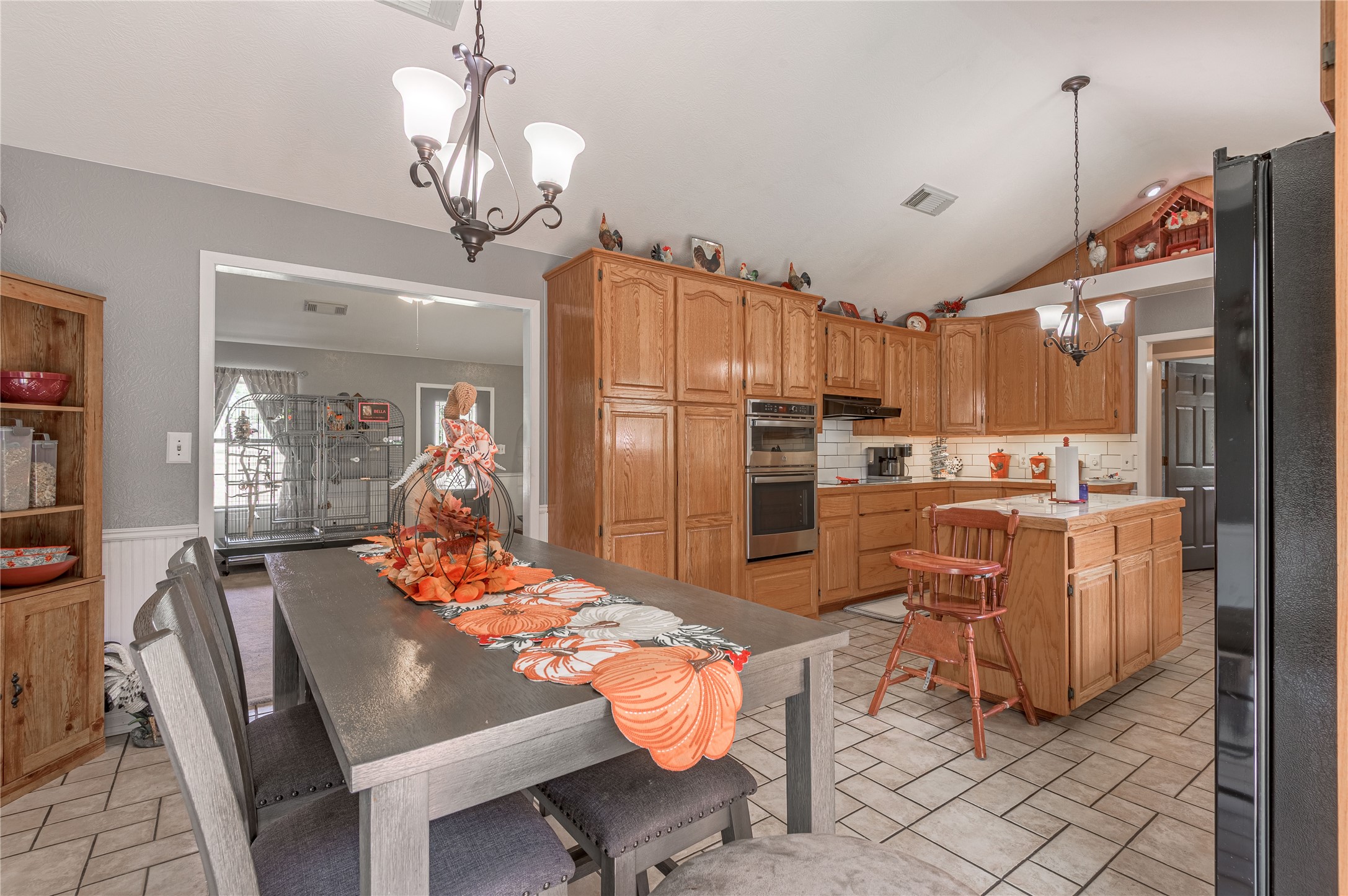 70 William Thomas Road Huntsville, TX 77320 - Photo 11 of 50 a kitchen with stainless steel appliances granite countertop a refrigerator a sink dishwasher a dining table and chairs with wooden floor
