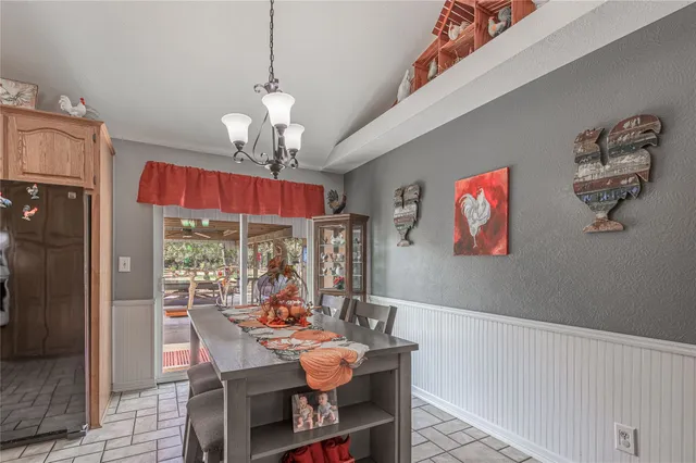 a view of a dining room with furniture a chandelier and wooden floor