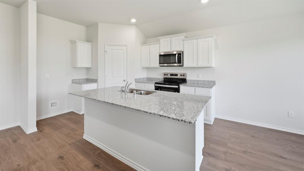 4101 Oakcrest Lane Princeton, TX 75407 - Photo 23 of 26 a kitchen with stainless steel appliances a sink stove and microwave