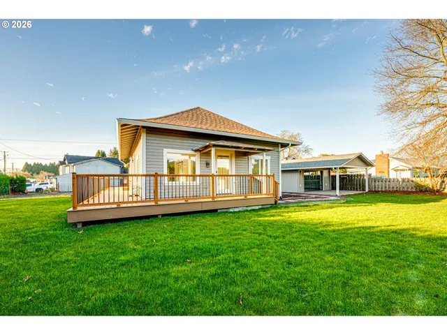 a view of a house with a yard and deck