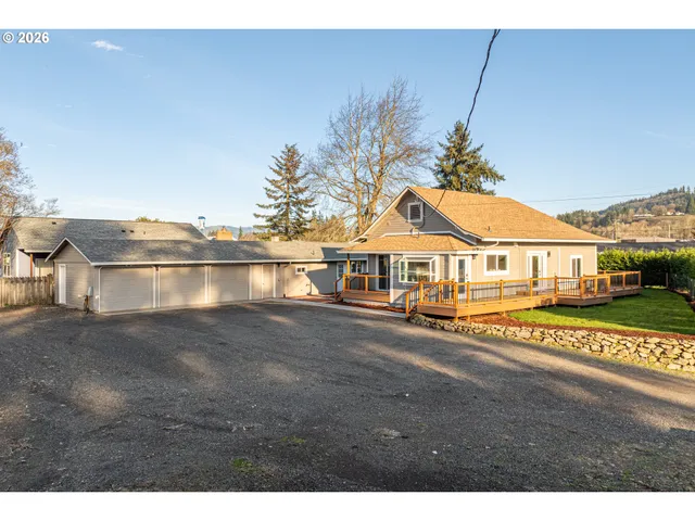 a view of a house with big yard and a large tree center