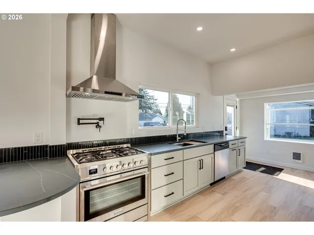 a kitchen with stainless steel appliances a stove a sink and a microwave