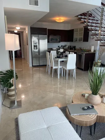 a dining room with furniture a window and kitchen view