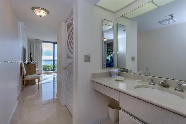 a en suite bathroom with a granite countertop sink and a large mirror