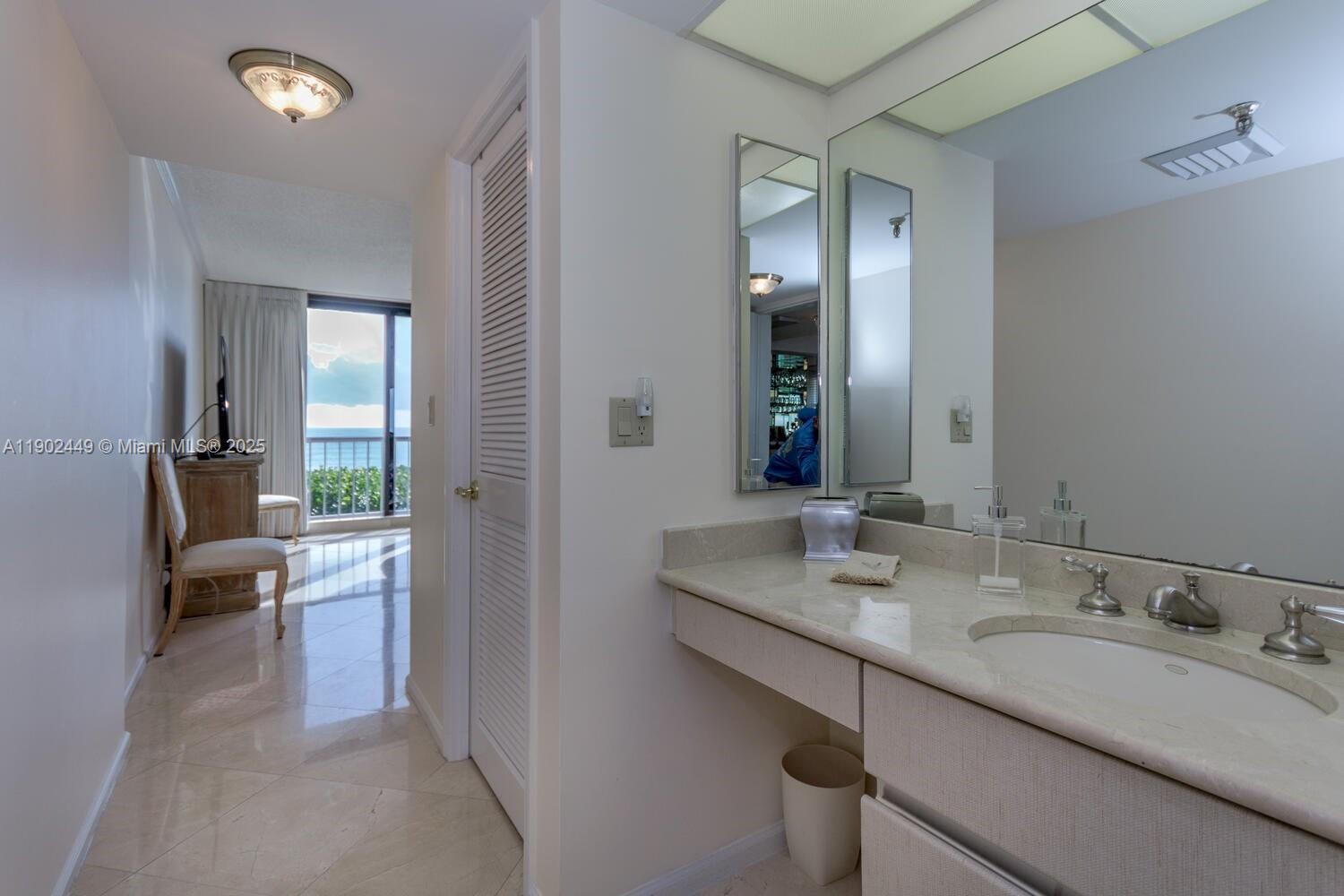 290 Celestial Way, Unit 2 Juno Beach, FL 33408 - Photo 12 of 40 a en suite bathroom with a granite countertop sink and a large mirror