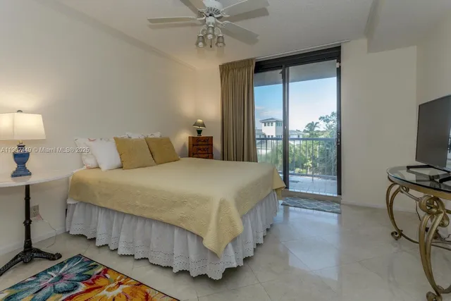 a bedroom with a bed a chandelier and dresser