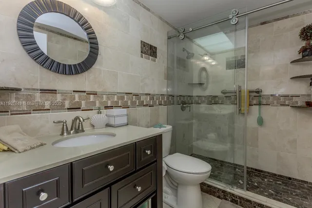 a bathroom with a toilet a sink and mirror