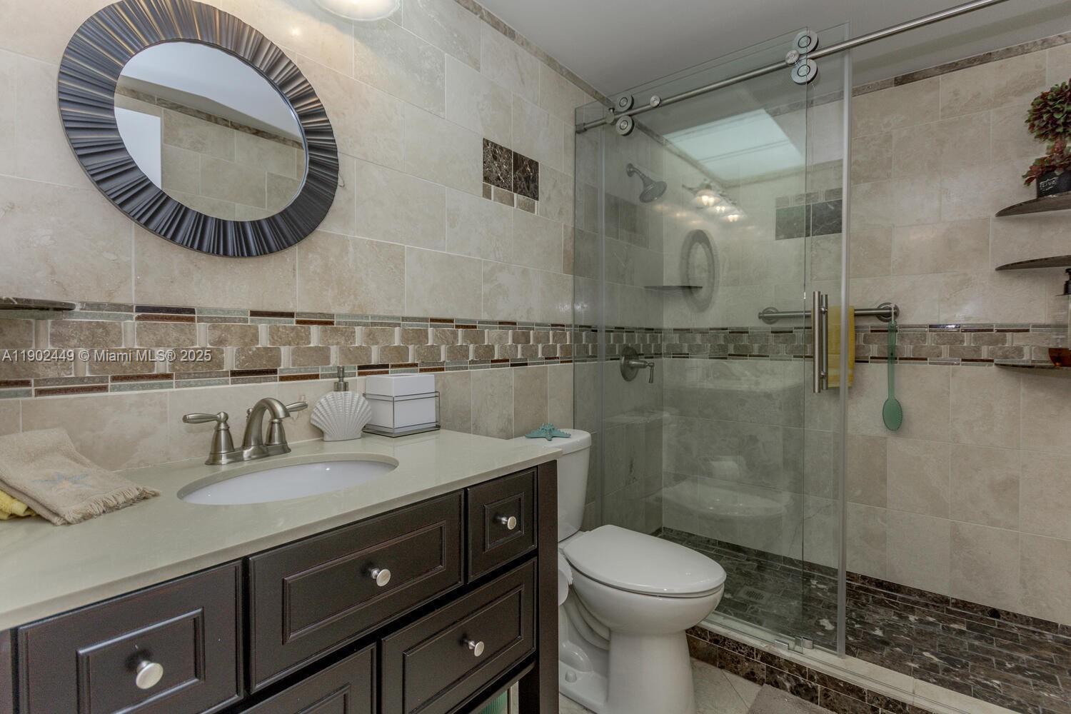 290 Celestial Way, Unit 2 Juno Beach, FL 33408 - Photo 24 of 40 a bathroom with a toilet a sink and mirror