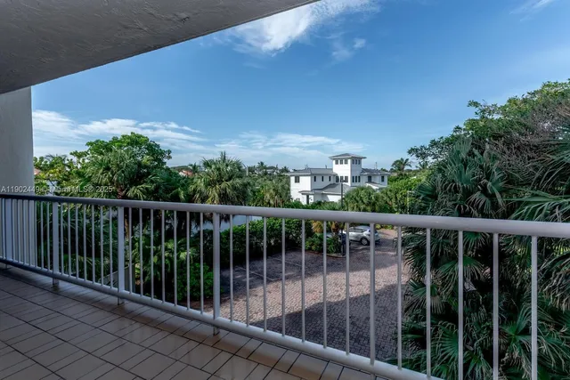 a view of swimming pool with a table and chair under palm trees