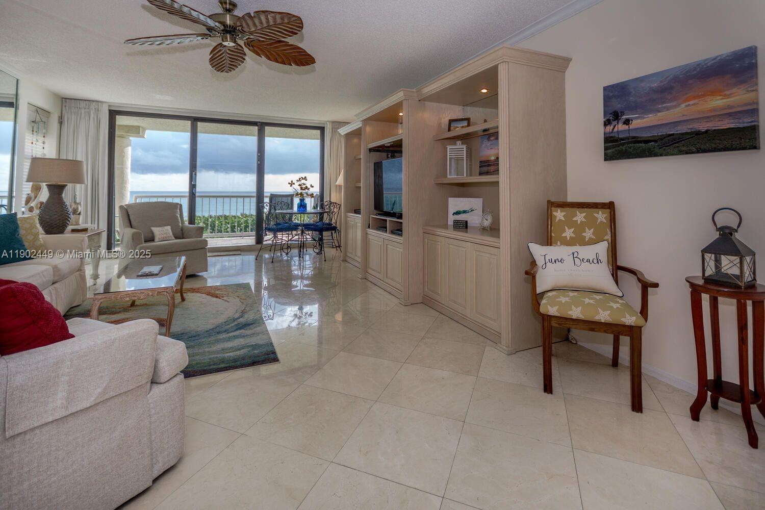 290 Celestial Way, Unit 2 Juno Beach, FL 33408 - Photo 4 of 40 a living room with furniture and a large window