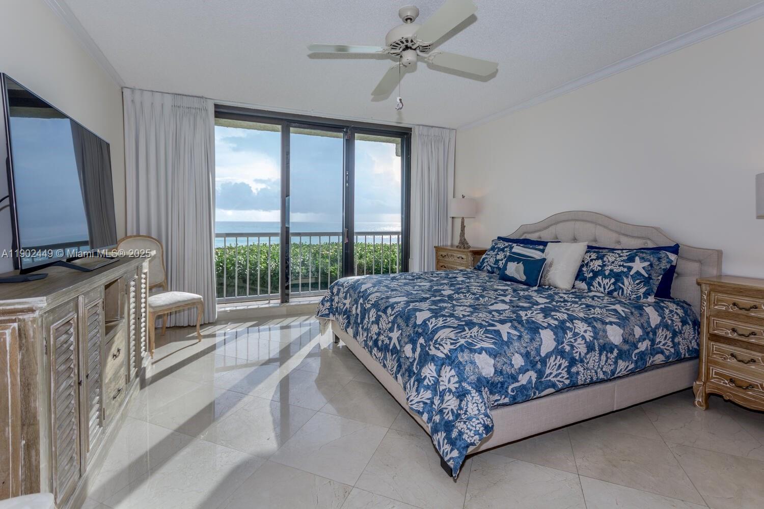 290 Celestial Way, Unit 2 Juno Beach, FL 33408 - Photo 9 of 40 a bedroom with a large bed and a flat tv screen on dresser