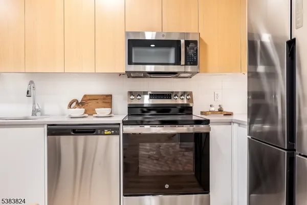 a kitchen with stainless steel appliances granite countertop a stove a refrigerator and a microwave