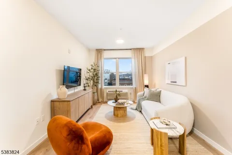 a living room with furniture a fireplace and a large window