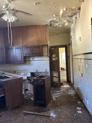 an empty room with a ceiling fan and closet area