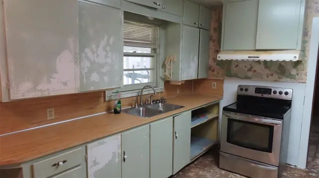 a kitchen with a sink stove and cabinets