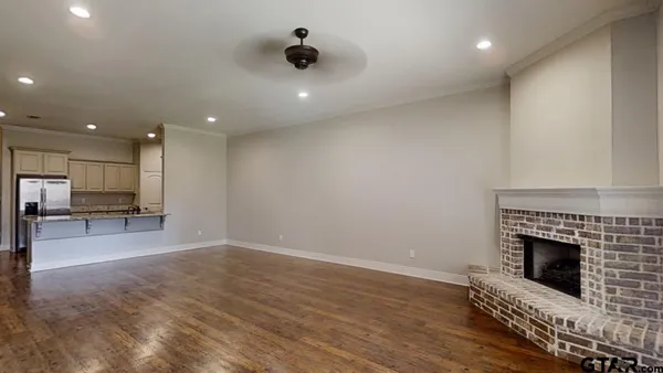 a view of a livingroom with fireplace and kitchen view