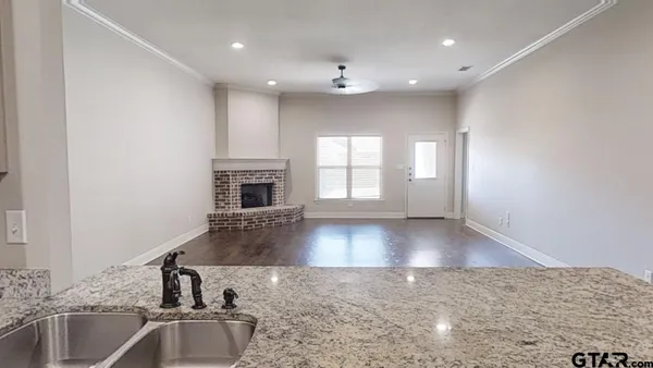 a view of a kitchen with a sink and dishwasher with wooden floor