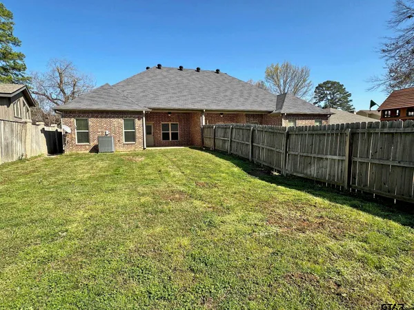 a view of a house with a yard and wooden fence