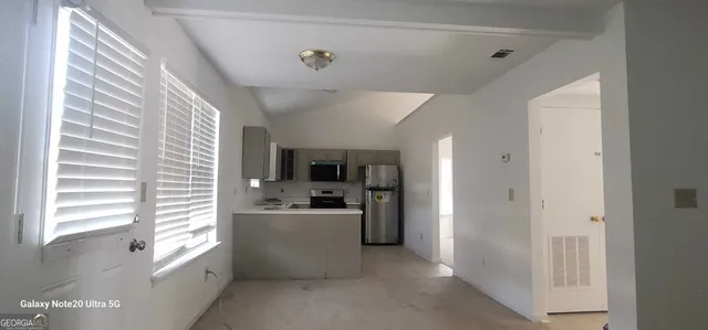 a kitchen with a sink a refrigerator and cabinets