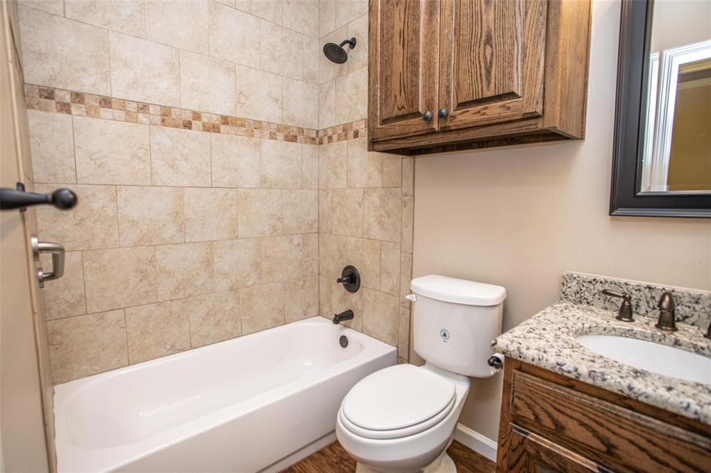 455 Neals Hill Road Oak Ridge, TX 76240 - Photo 18 of 19 a bathroom with a granite countertop bathtub sink vanity mirror and toilet