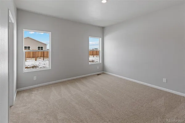 an empty room with windows and closet